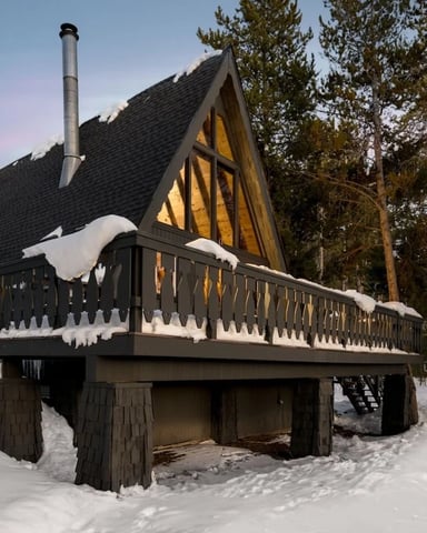 Lone mountain hut beneath dramatic rocky peaks